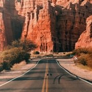 Road in Argentina with red rock mountains in the back Road in Argentina with red rock mountains in the back