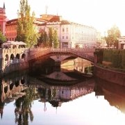 River in Slovenia, with sun reflecting in the water and old nice buildings on the sides River in Slovenia, with sun reflecting in the water and old nice buildings on the sides